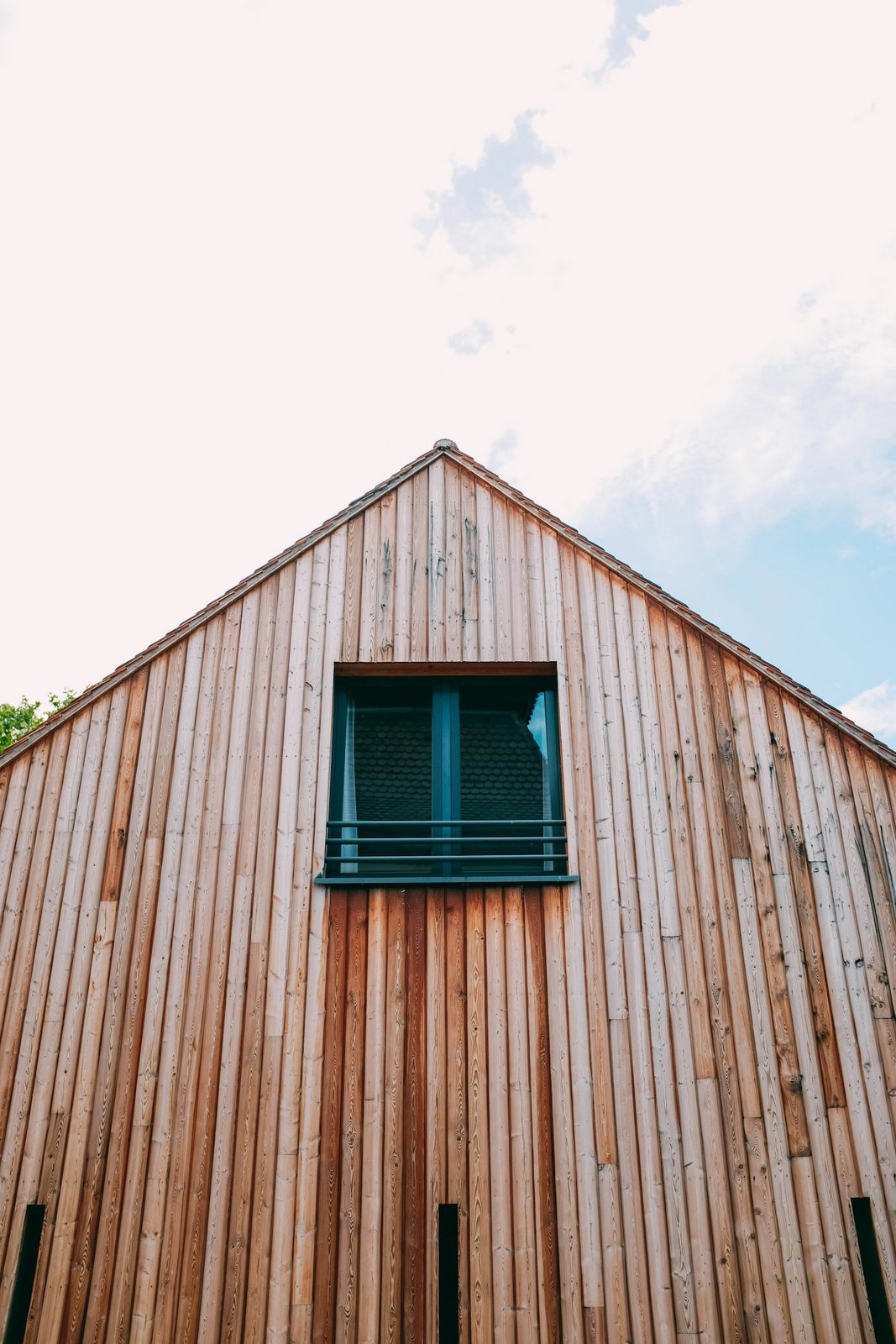 Puntgevel met verticale houten gevelbekleding en een raam